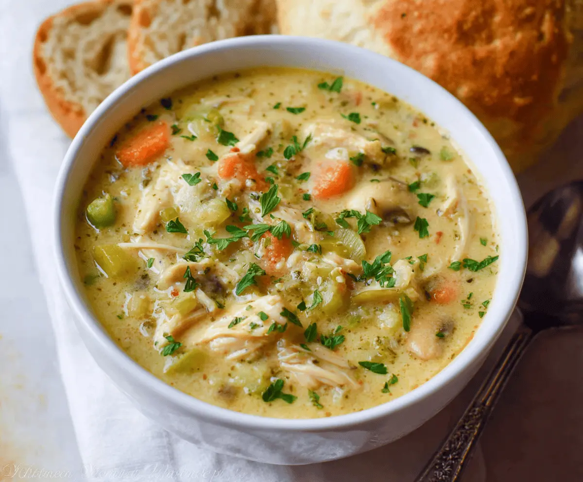 Creamy and comforting Healthy Chicken Pot Pie Soup topped with fresh herbs and crispy pastry crust, perfect for a nourishing meal.
