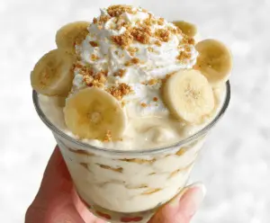 Creamy Chick-fil-A Banana Pudding topped with whipped cream and sliced bananas, served in a glass dessert bowl.