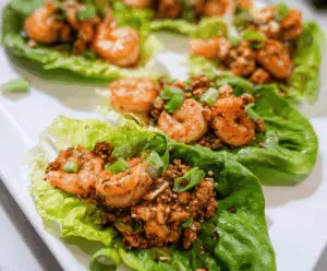 Delicious chicken and shrimp lettuce wraps garnished with fresh herbs, perfect for a healthy appetizer or light meal.