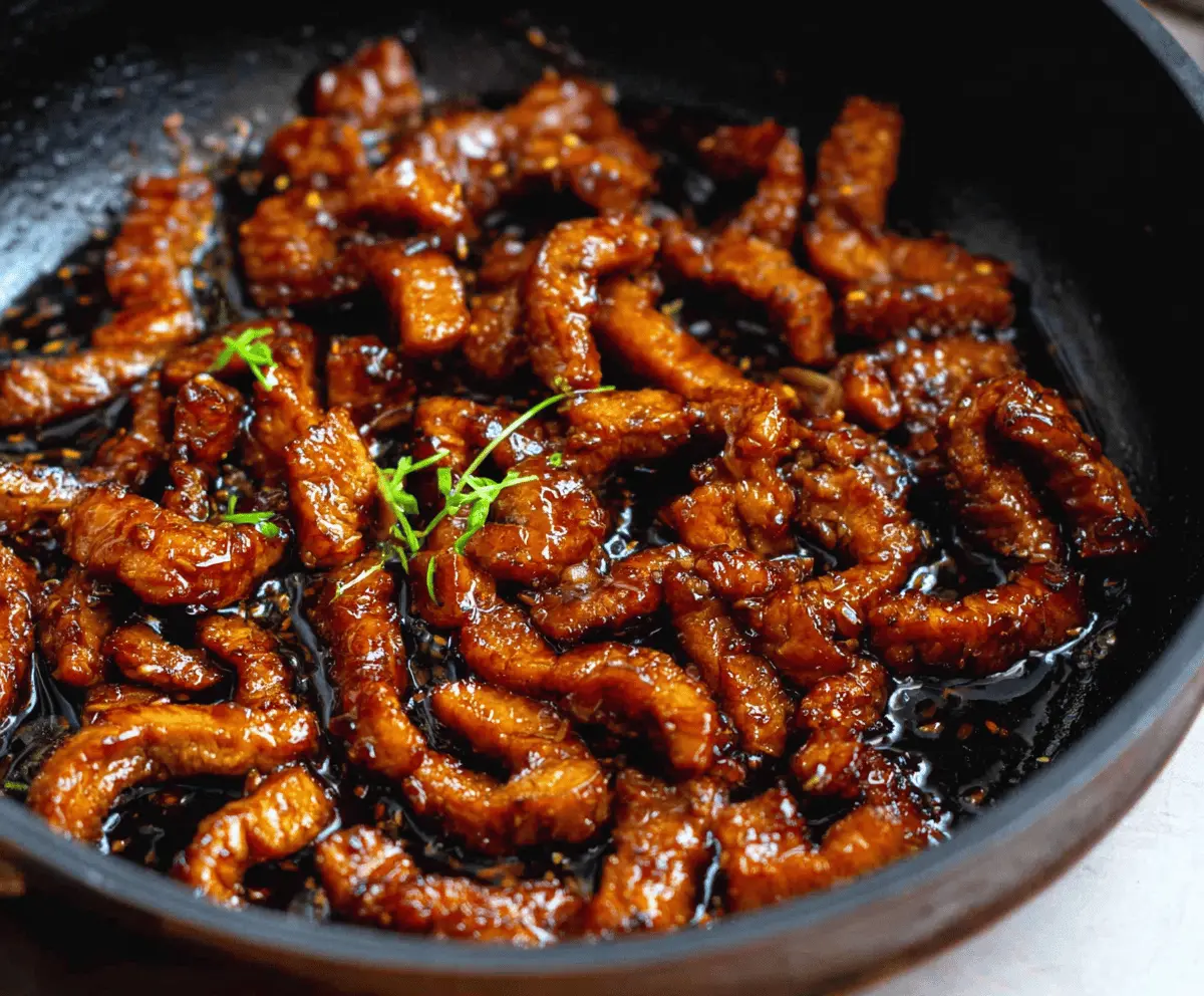 Delicious Sticky Honey Garlic Pork served with fresh vegetables on a plate, showcasing a glossy glaze and tender meat.