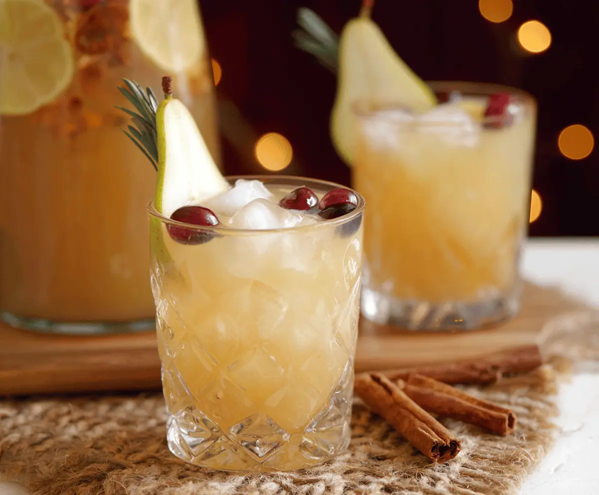 Festive Thanksgiving Punch with spicy pear flavor in a glass pitcher, perfect for non-alcoholic celebrations.