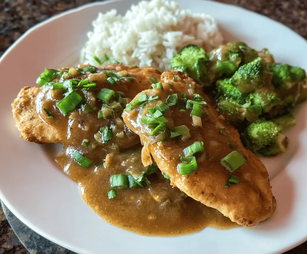 Juicy chicken breasts topped with spicy chipotle green onion gravy on a rustic plate.