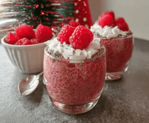 Delicious Raspberry Chia Seed Pudding in a clear glass topped with fresh raspberries and mint