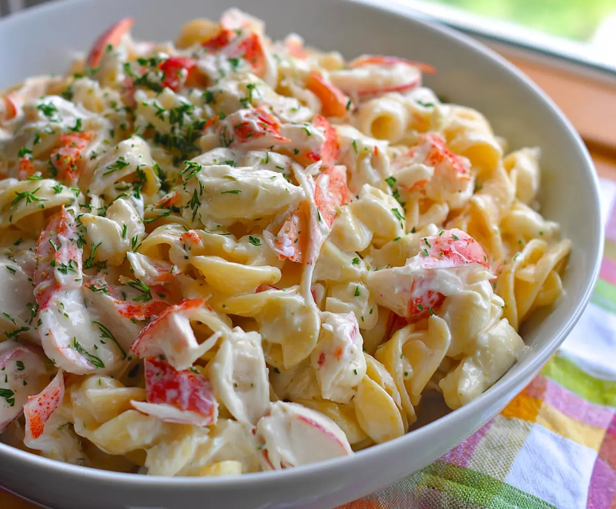 Fresh crab pasta salad with cherry tomatoes and parsley, perfect for summer picnics
