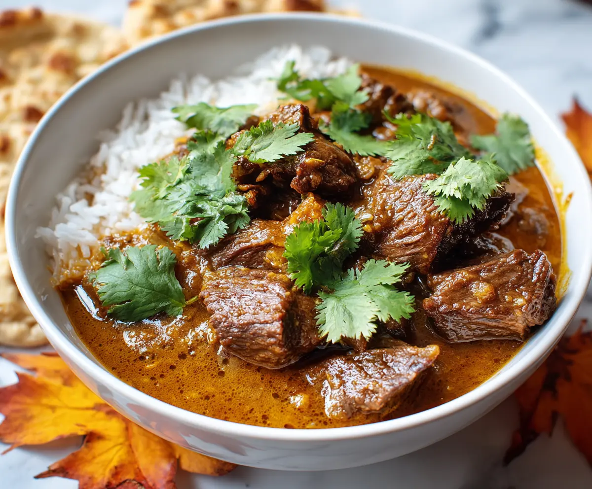 Delicious slow cooker beef coconut curry served with rice and fresh herbs