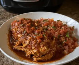 Delicious slow cooker salsa chicken served with fresh cilantro and lime slices.