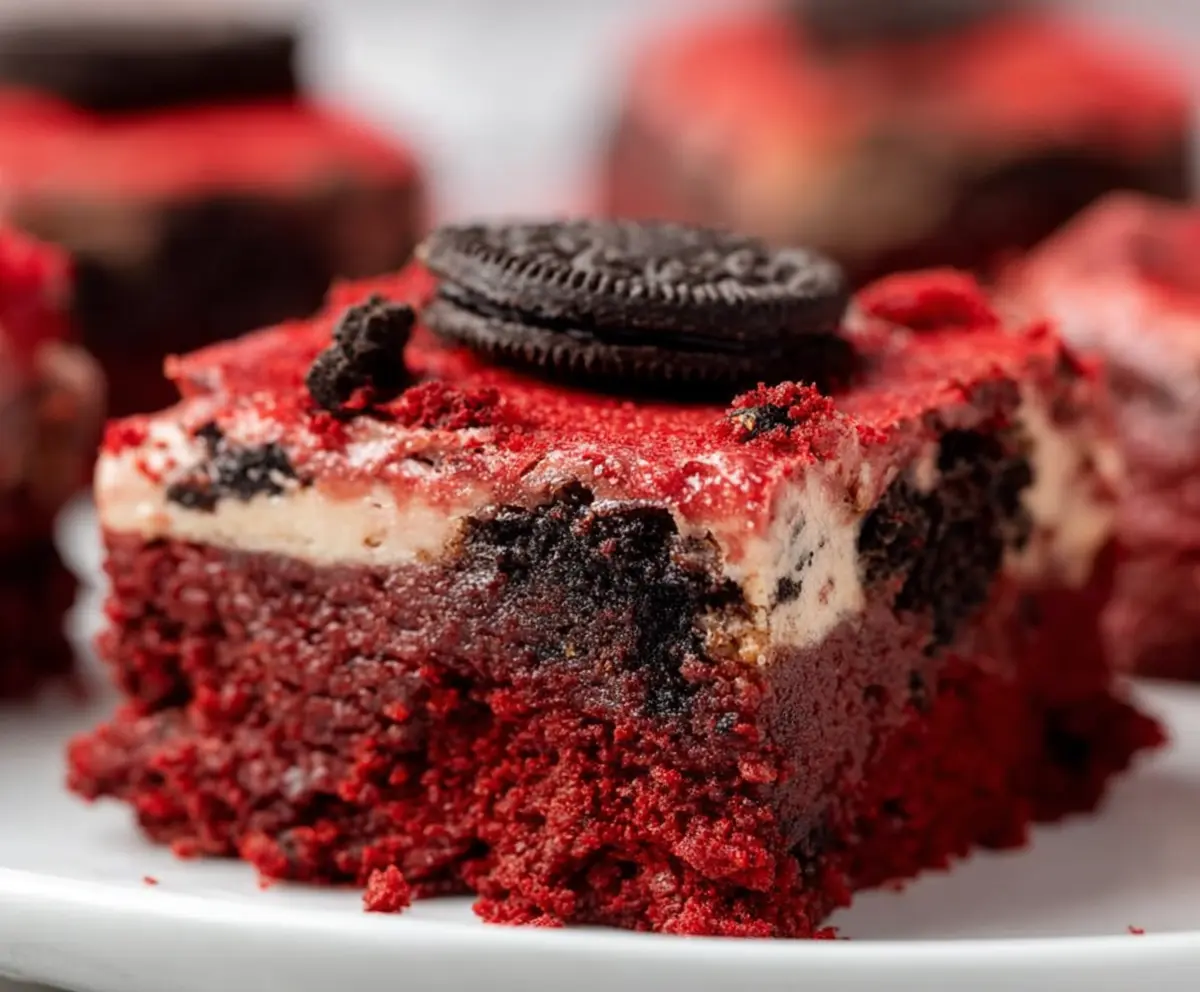 Delicious Oreo Red Velvet Brownies with creamy frosting and chocolate crumbs on top.