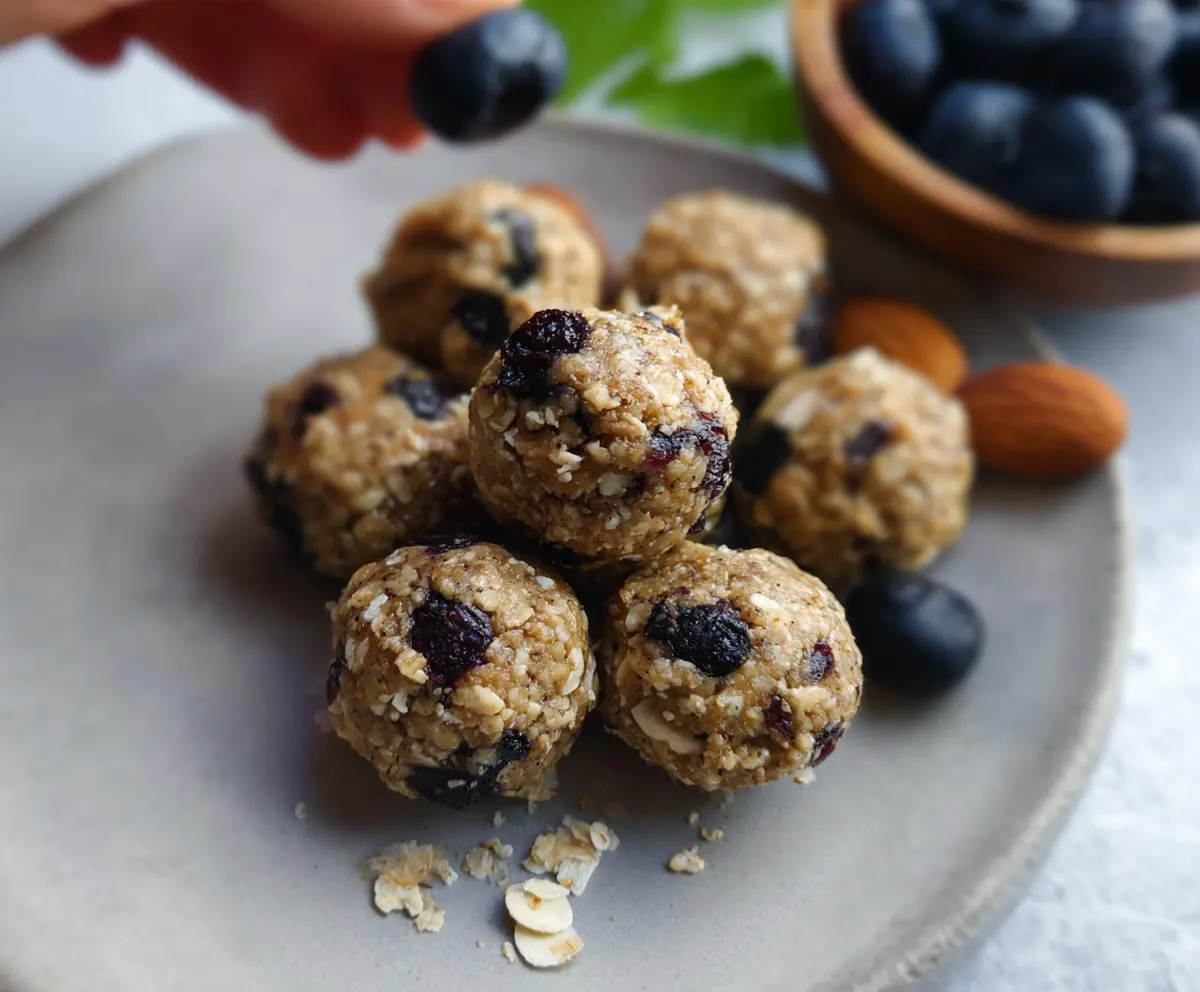 Healthy blueberry almond energy bites in a white bowl on a wooden table